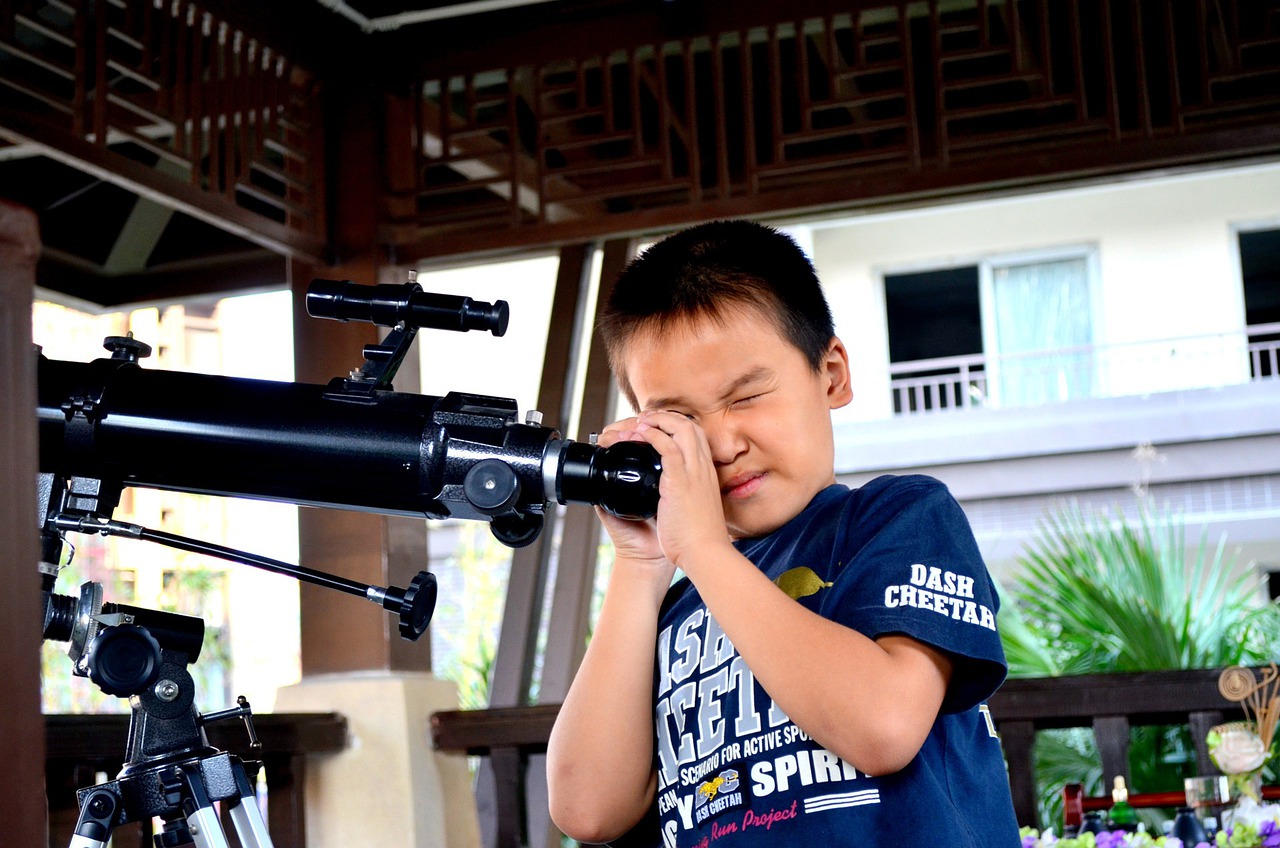 boy looking through astrophotography telescope